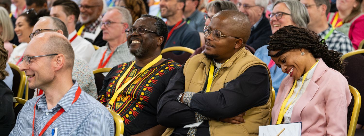 People smile in a conference audience