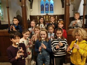 Group of children playing recorders in church