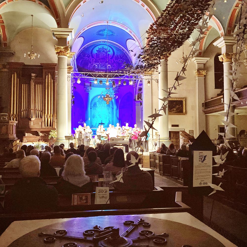 Church with full congregation, paper cranes hanging from the ceiling.