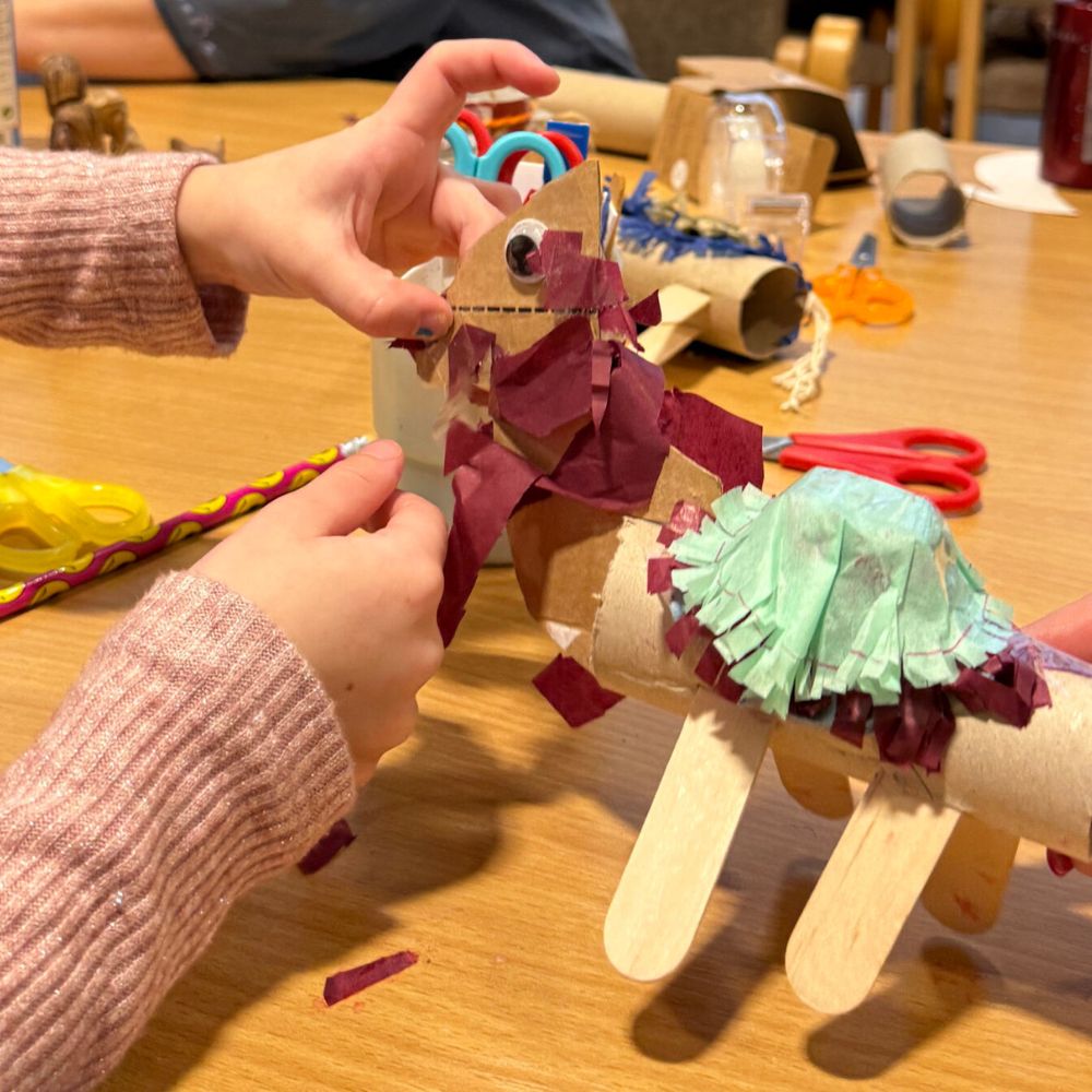 A child's hands create a craft made out of paper.