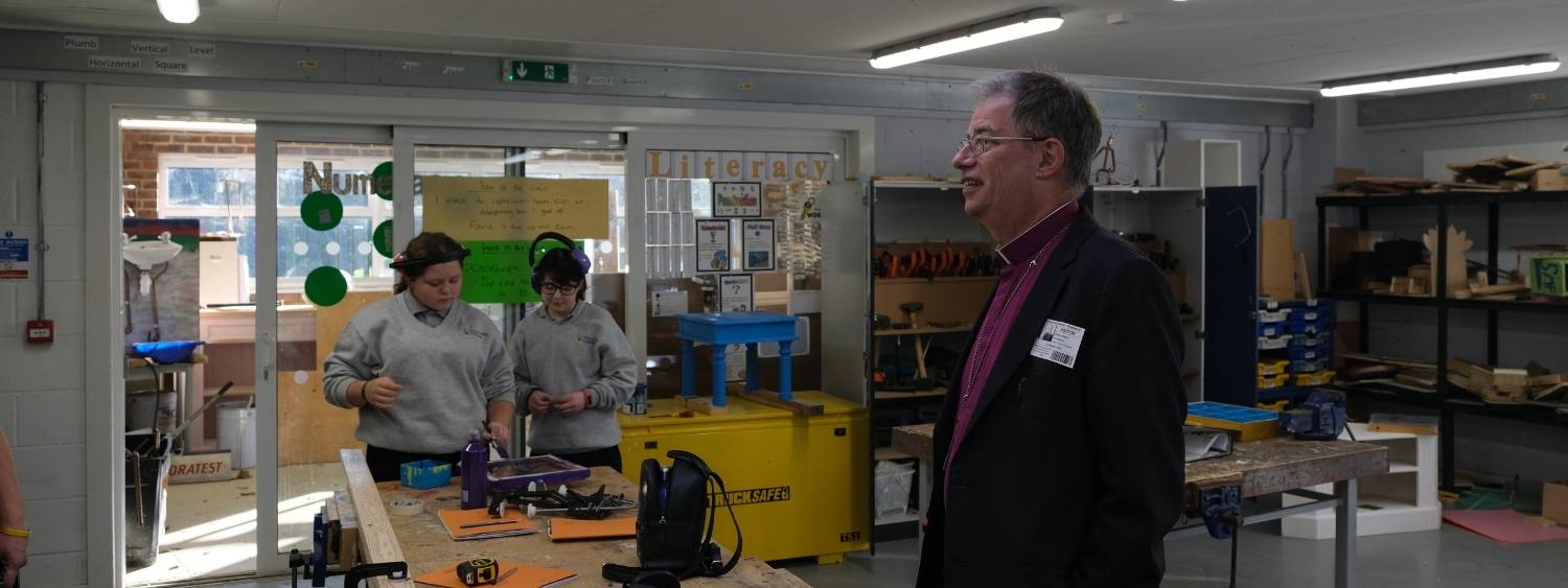 Bishop of Oxford standing in design technology classroom with two female pupils