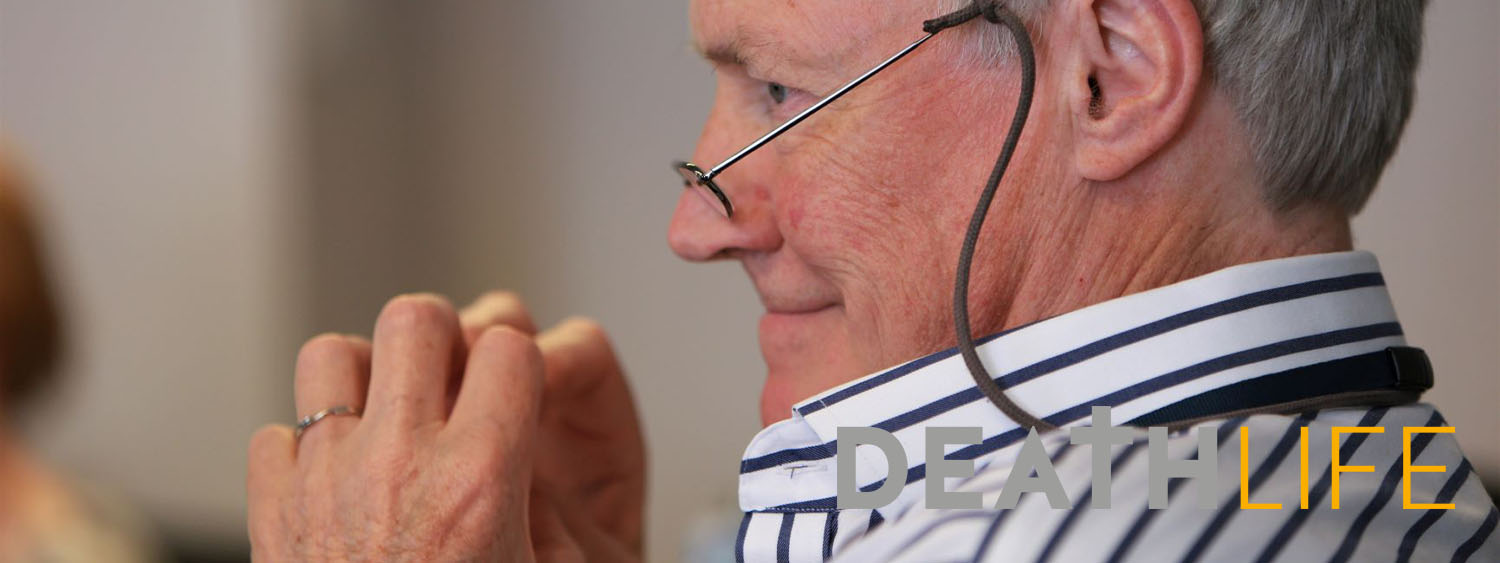 Older man with glasses looks on during a workshop