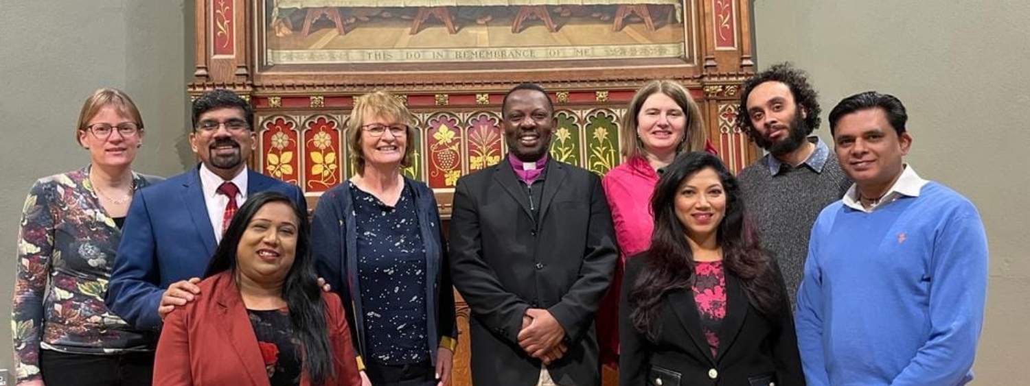 Members of the leadership team at St Paul's Church are standing in a row and smiling in front of a large painting