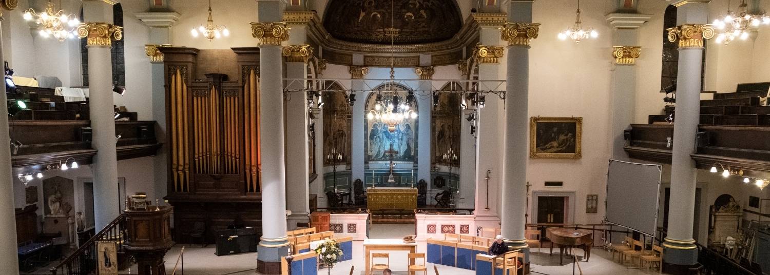 St Mary's, Banbury in large iconic design, 4 large white and gold pillars, a large organ to the left and balcony seating to the left and right.