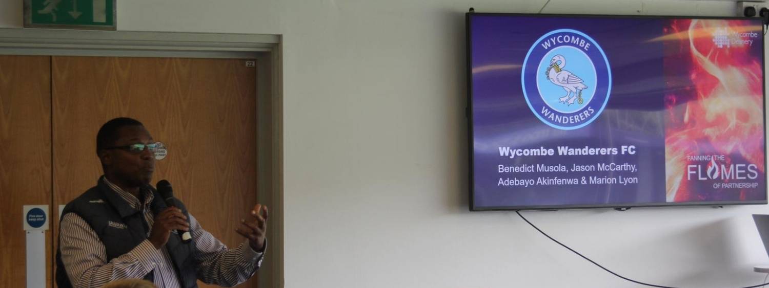 Chaplain to Wycombe Wanderers standing speaking holding microphone.