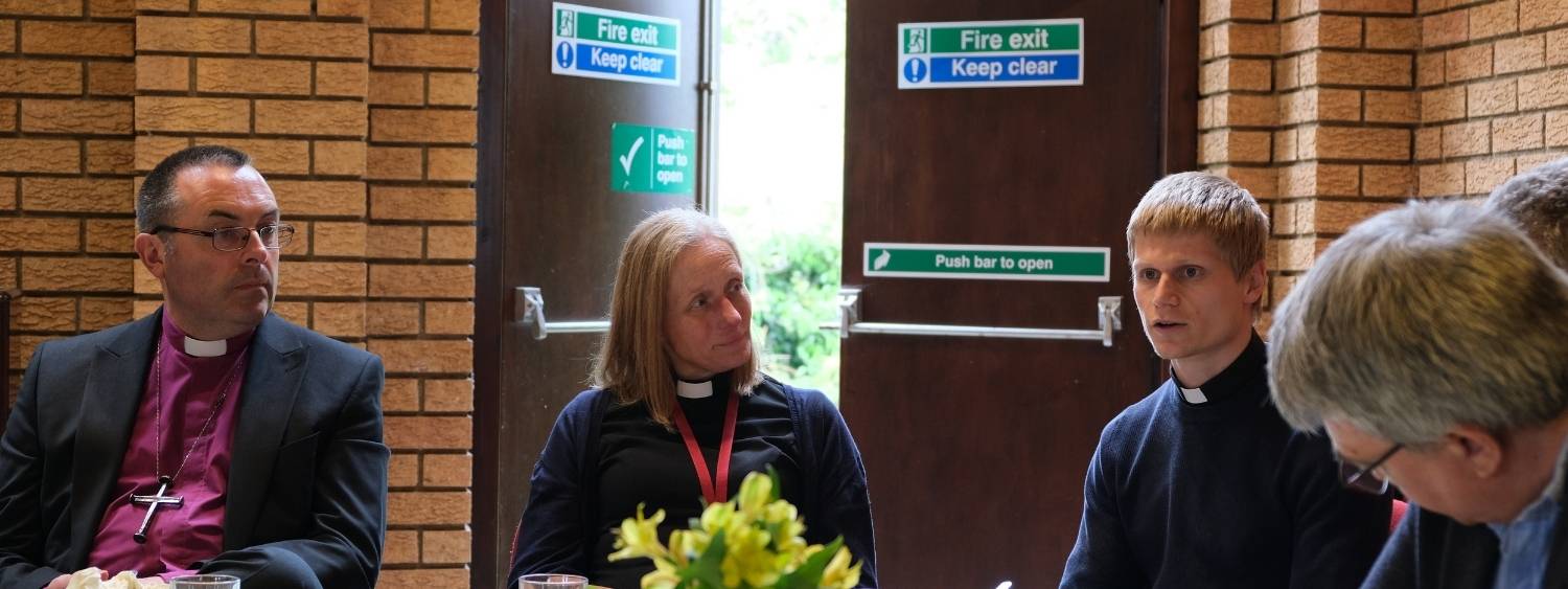 Bishop Gavin and clergy in the Abingdon Deanery sitting talking.