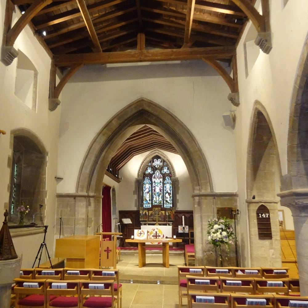 Inside of church building with uplighting and rows of chairs and an alter.