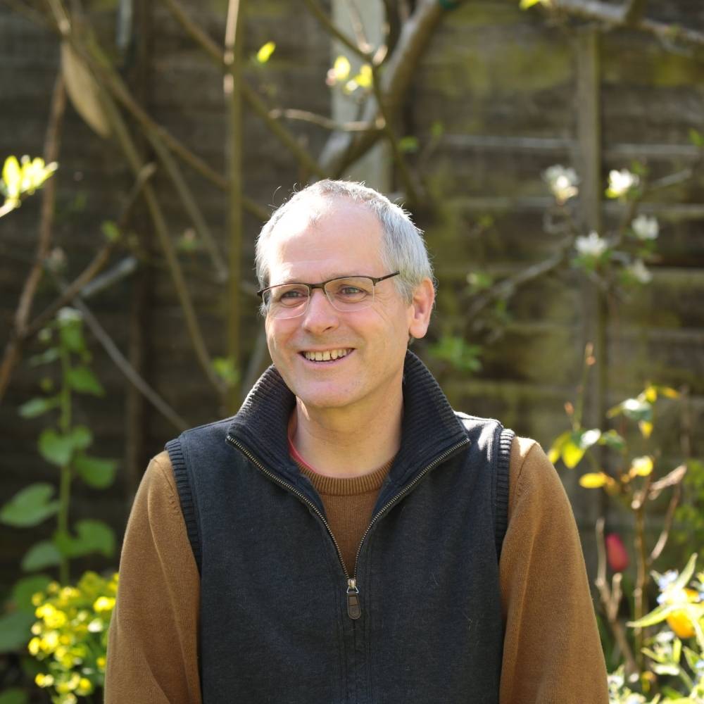 Matthew sitting in a garden smiling