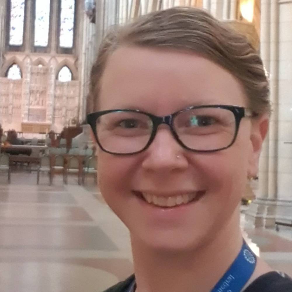 Headshot of Kate stood in a church