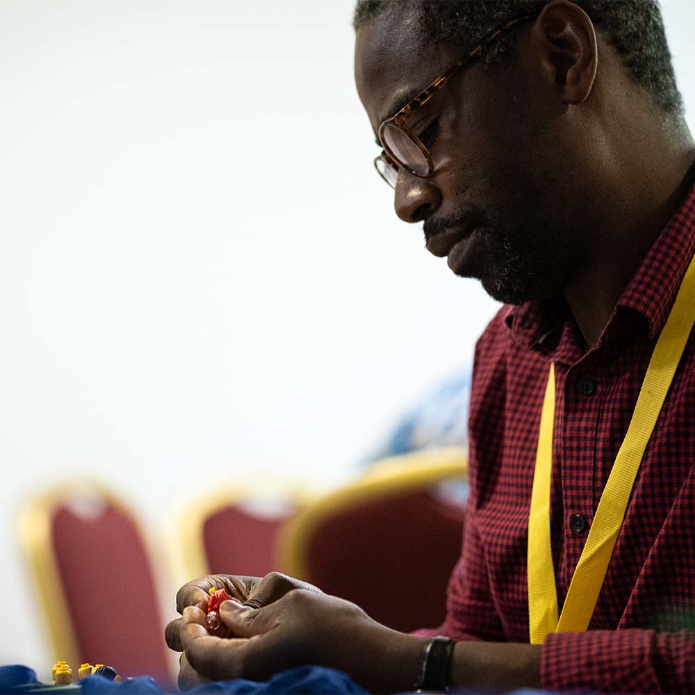 A member of clergy concentrates as he builds with Lego