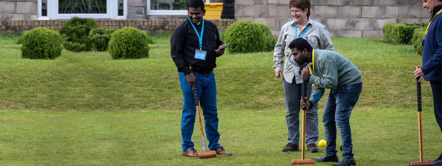 Clergy from Nandyal, south India, smile as they are taught to play croquet by clergy from the Diocese of Oxford