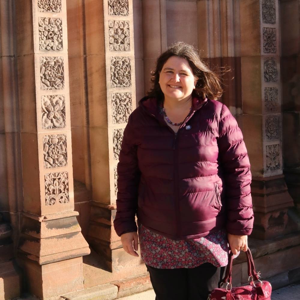 Carol Atkins standing outside a church smiling
