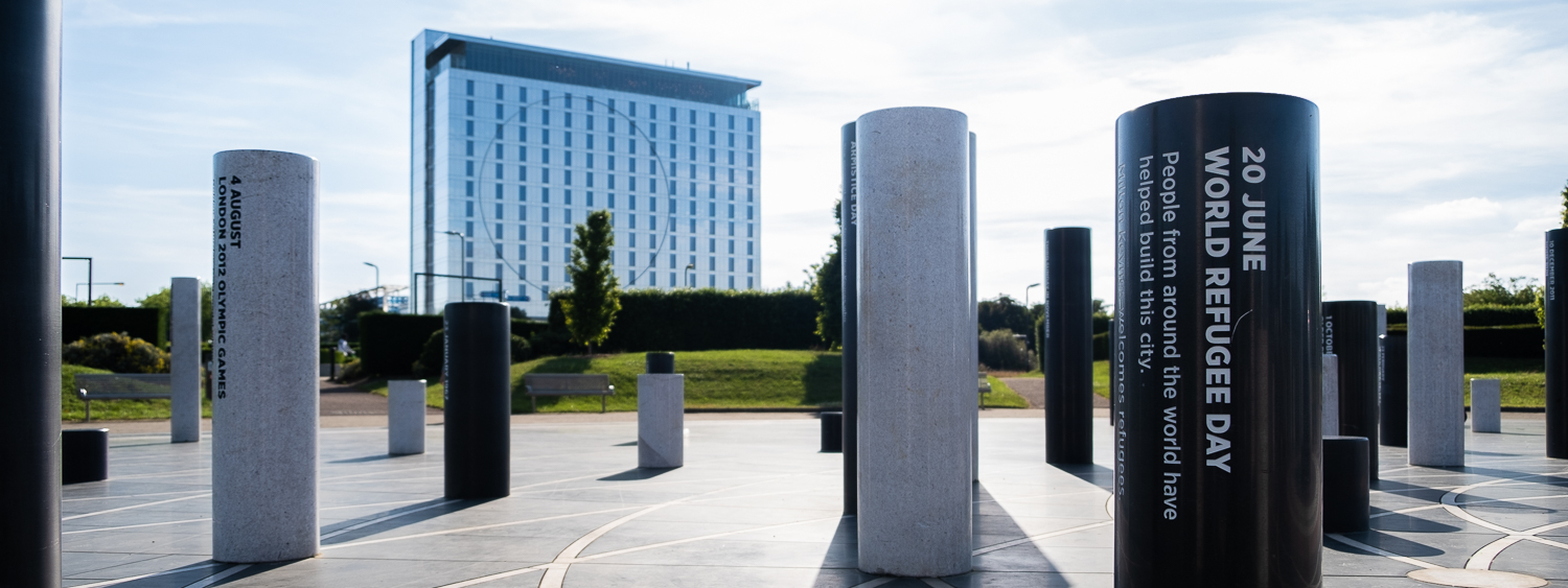 The Milton Keynes Rose - a collection of black and white pillars inscribed with messages marking key dates. In the foreground in a World Refugee Day pillar for 20 June which reads 