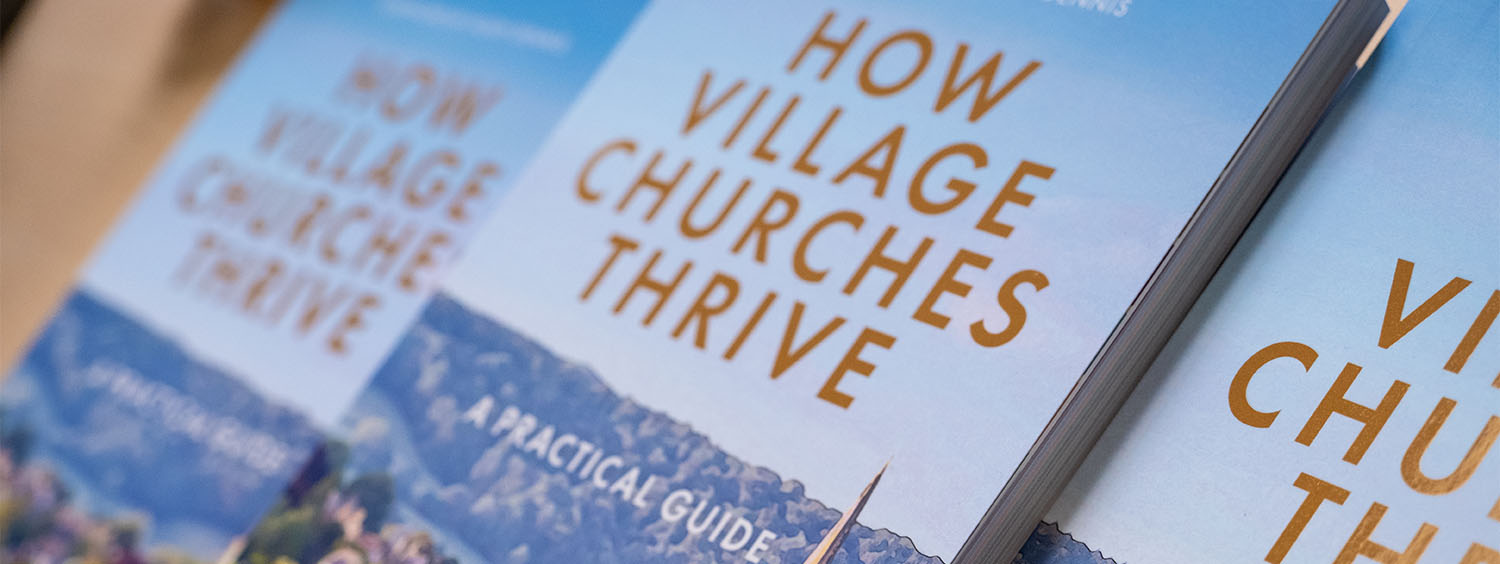 A stack of books entitled How Village Churches Thrive.