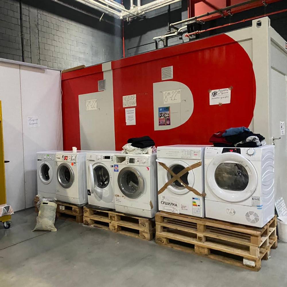 Line of washing machines in a warehouse in Poland housing Ukrainian refugees