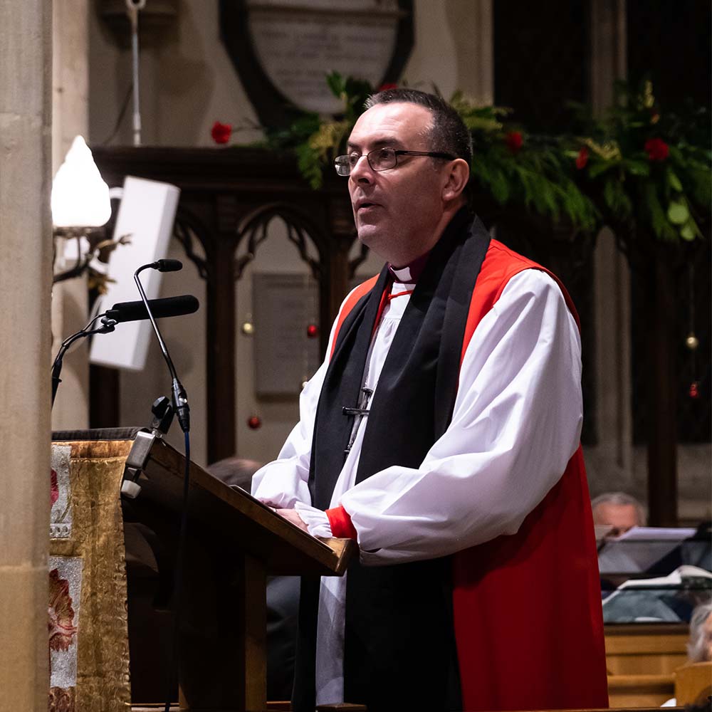 Bishop Gavin reads a sermon from the lectern at Dorchester Abbey at the BBC Radio Berkshire Carol Service,
