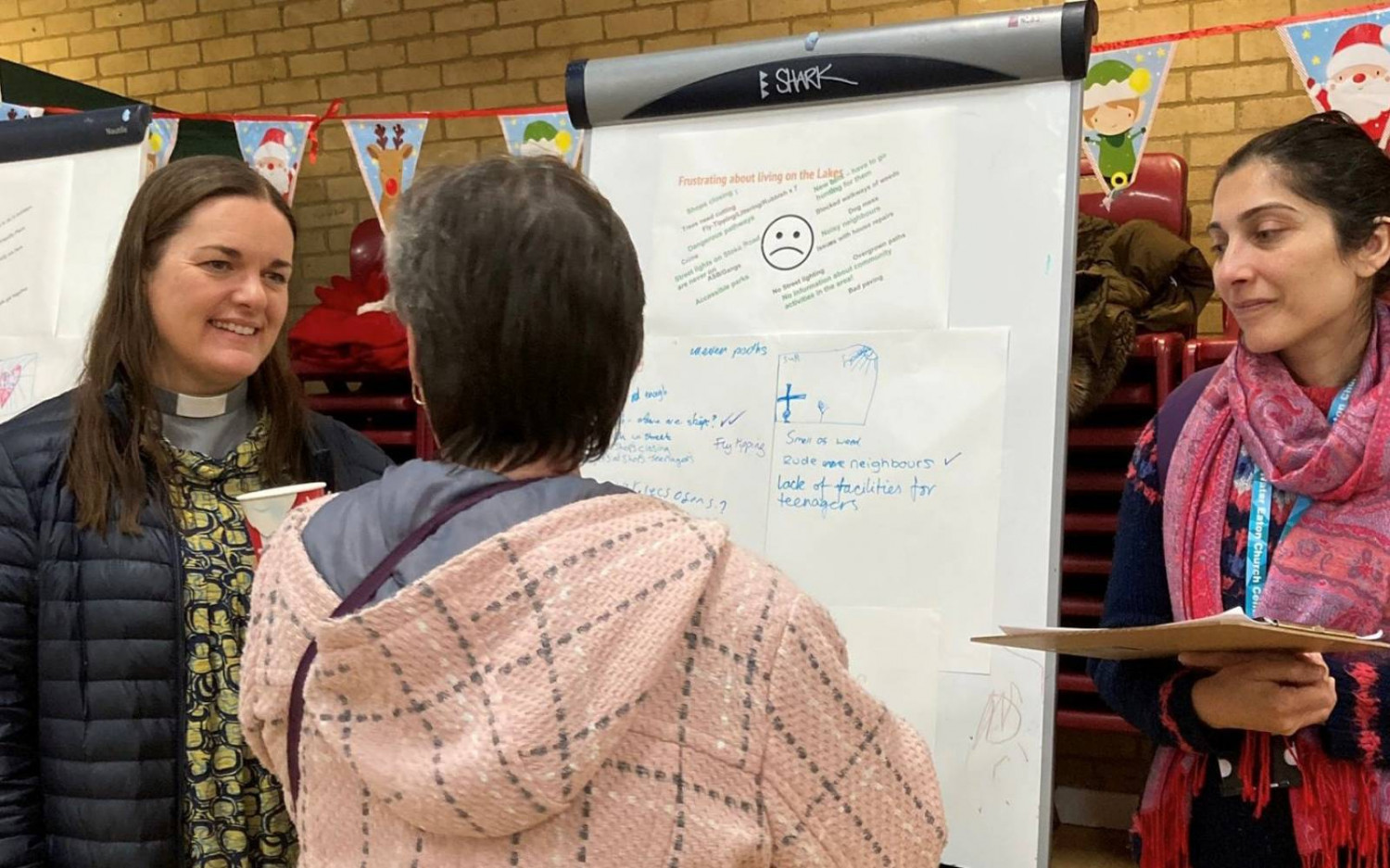 The Revd Catherine Butt and Nudrat Hopper, Community Organising lead, speaking to a local resident infront of a flipchart representing residents views.