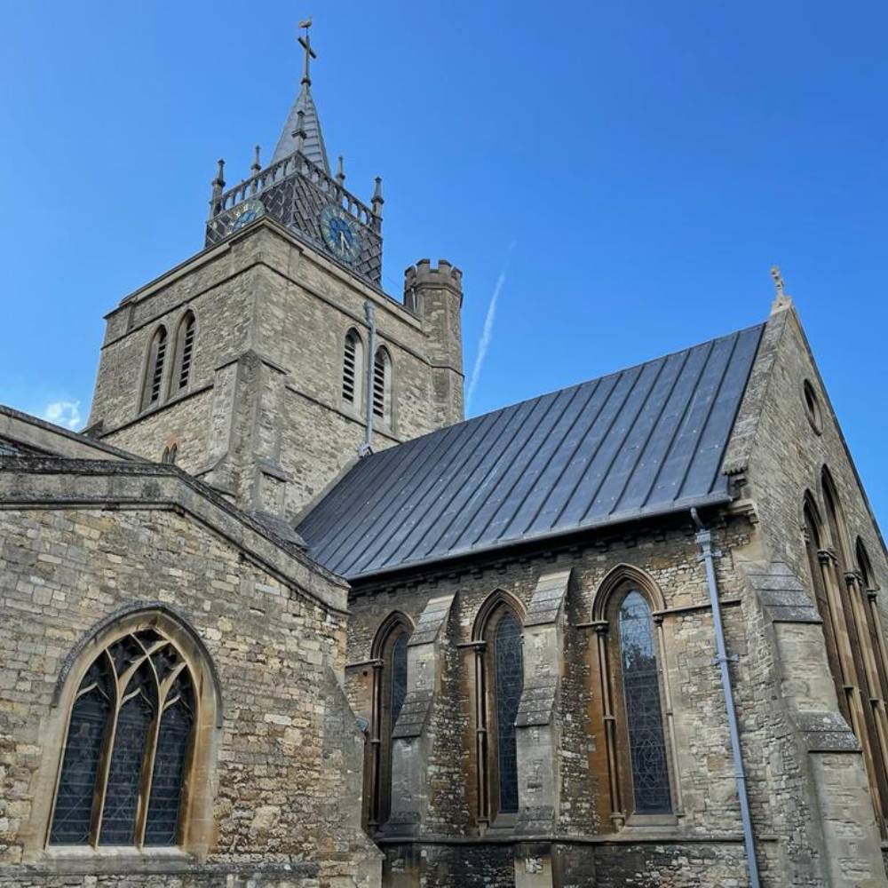 St Mary's Aylesbury church spire and chancel with new roof, clear blue sky in the background.