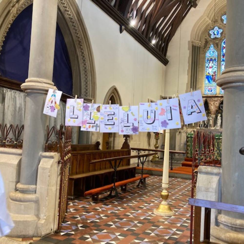 Paper hanging between two church pillars spelling out "Alleluia"