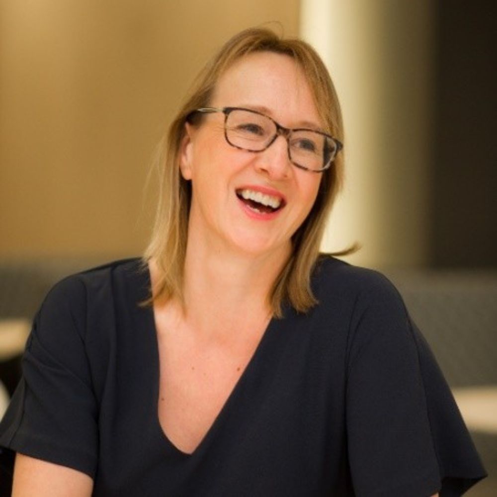 Headshot of Sophie Orme smiling, she is wearing glasses and a black, short sleeved top.