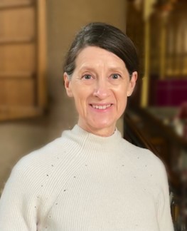 headshot of Lucie Spiers, she is smiling and wearing a cream jumper.