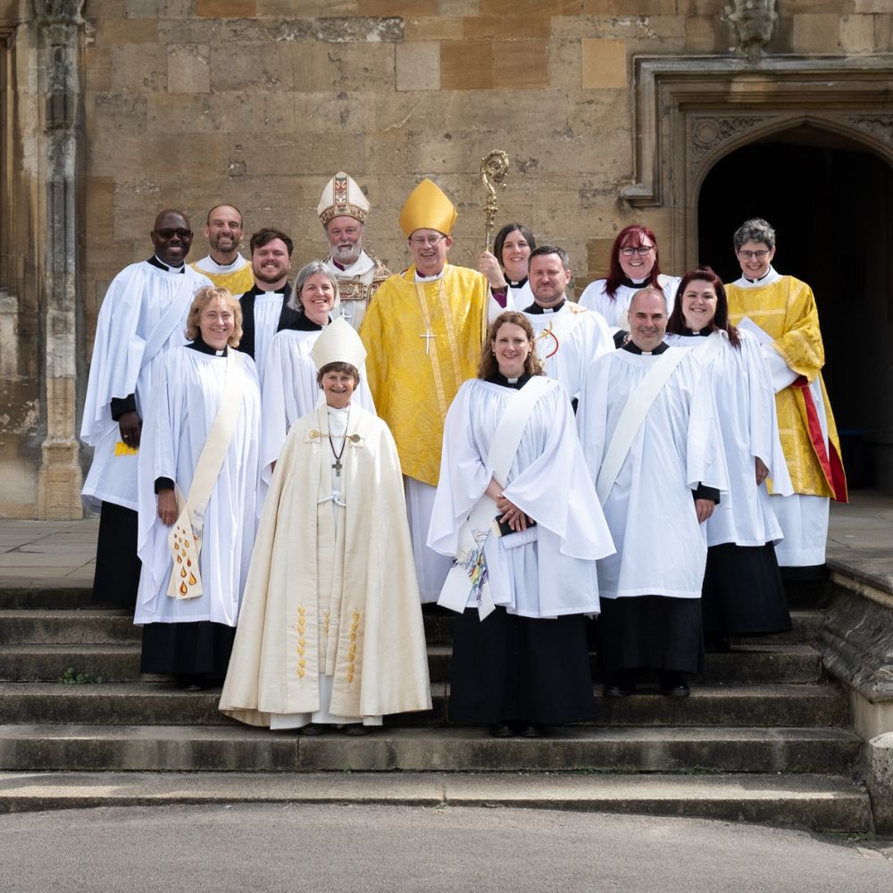 11 deacons stand with the Bishops of Oxford, Reading and Buckingham on steps at Christ Church Cathedral.